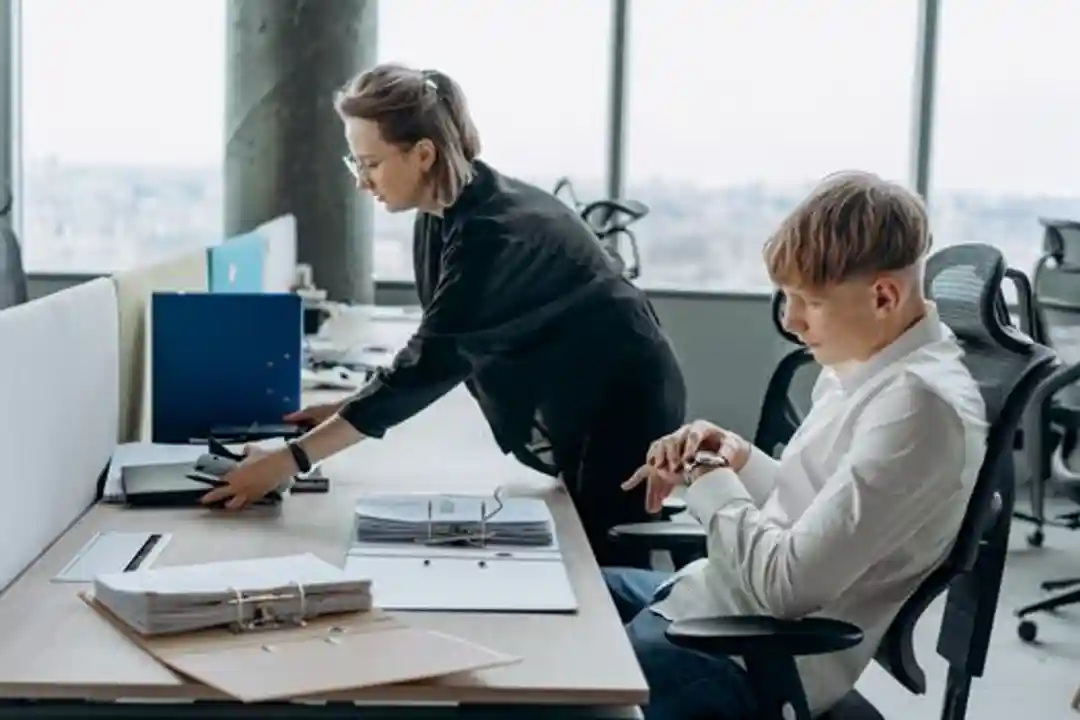 Profesional bisnis berkolaborasi di kantor modern dengan dokumen dan komputer.